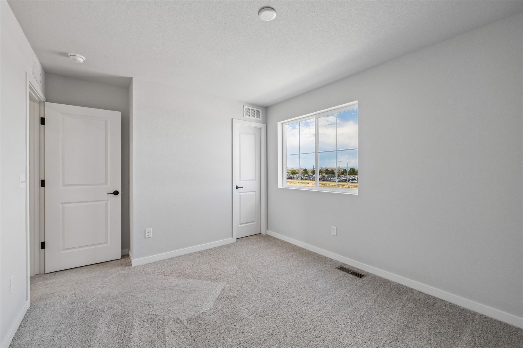 A room with white walls and a window with a blue and white design.