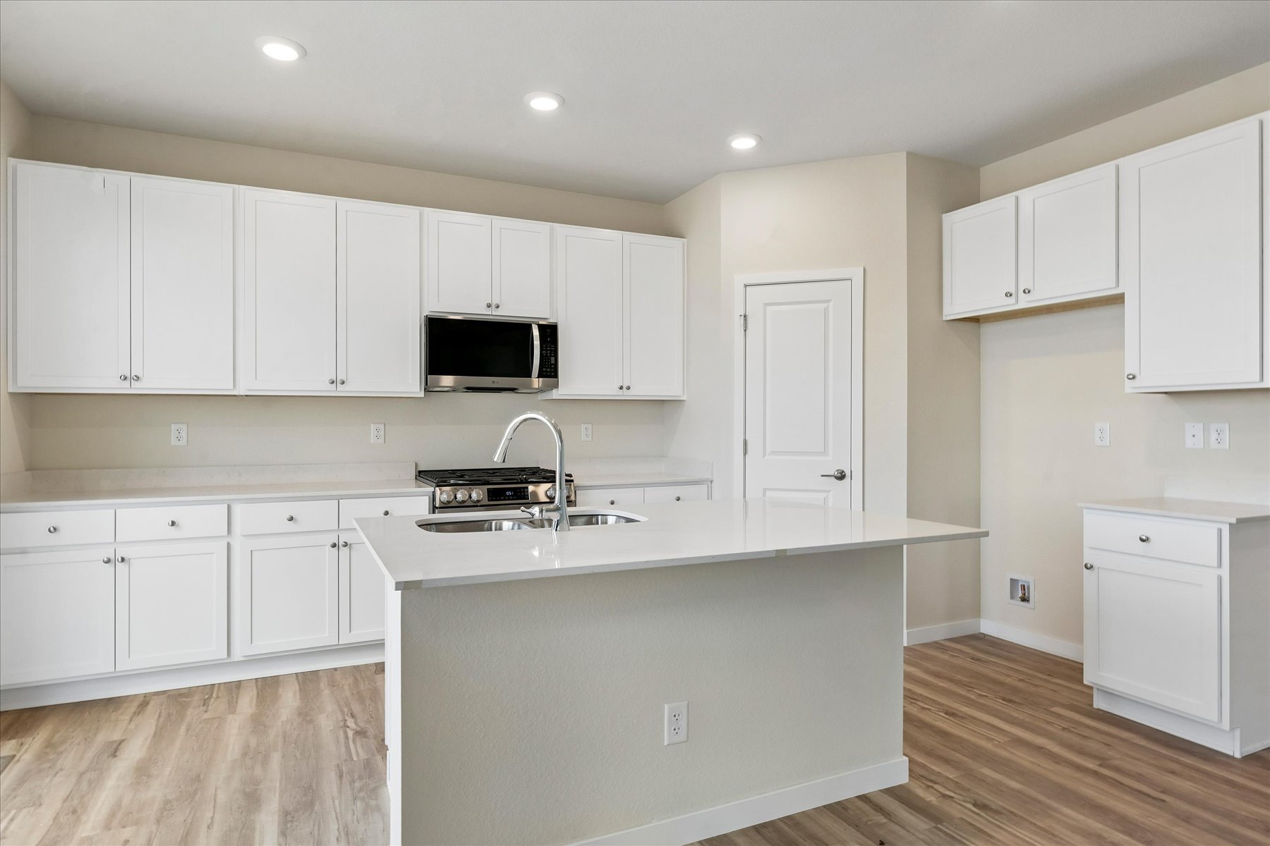 A kitchen with white cabinets.
