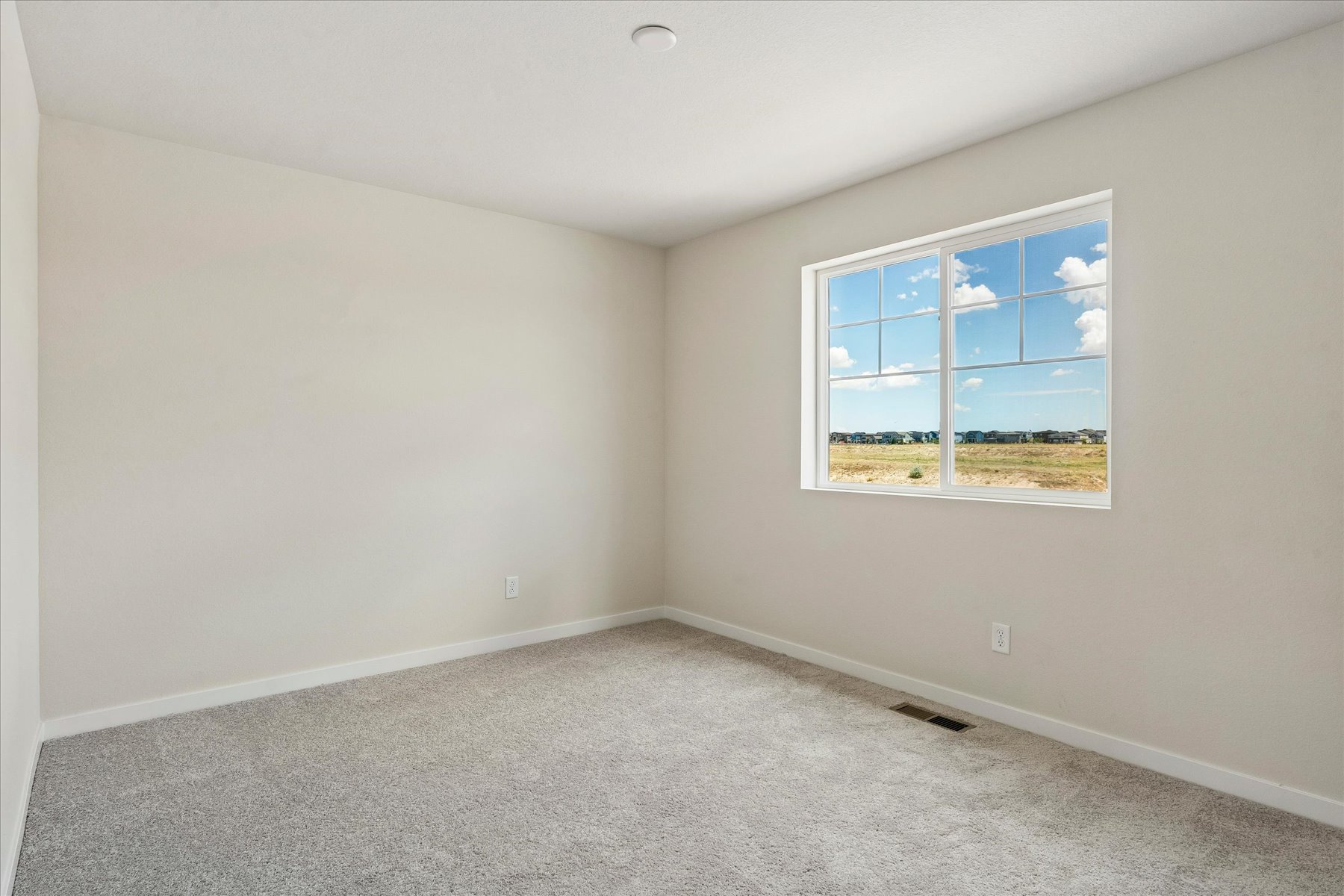 A room with a window and a carpet.
