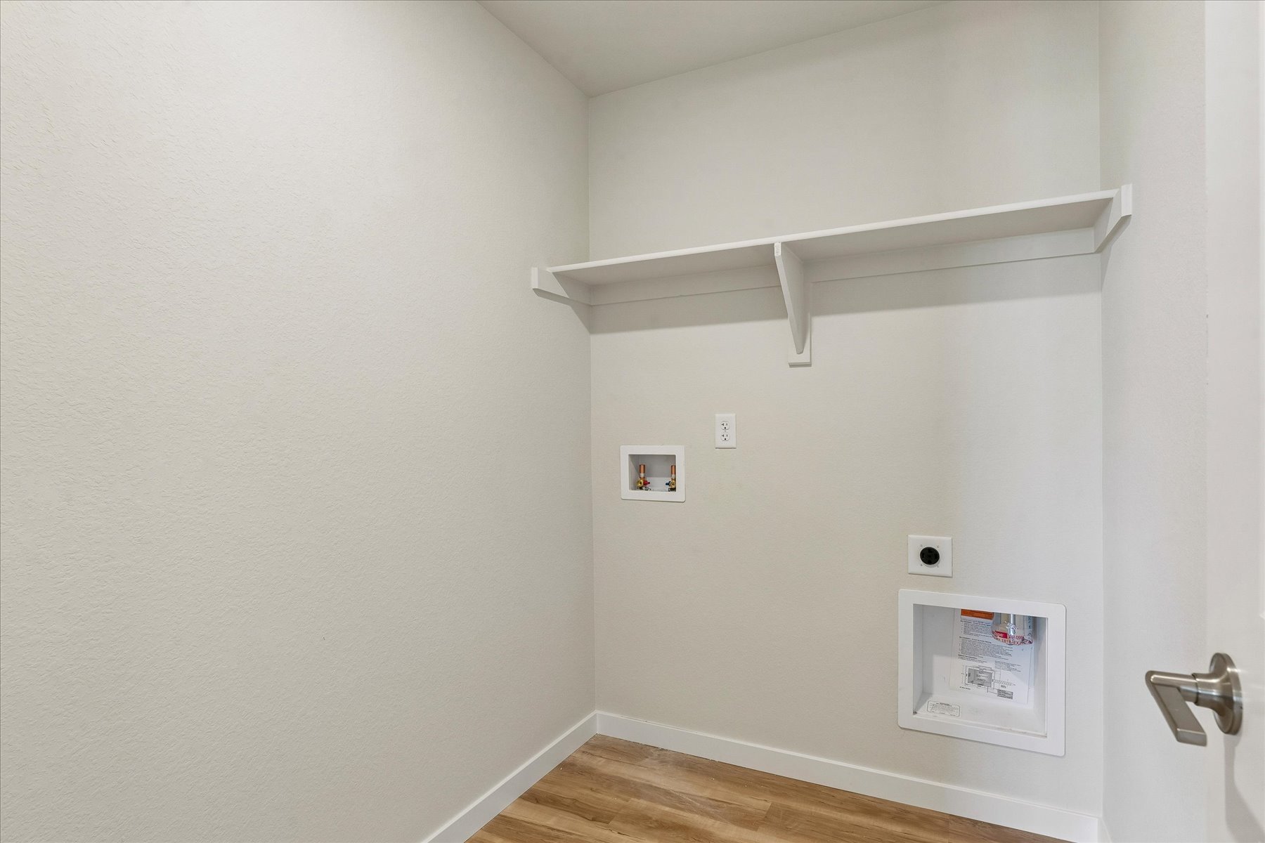 A white wall with a white shelf and a white wall with a white ceiling.