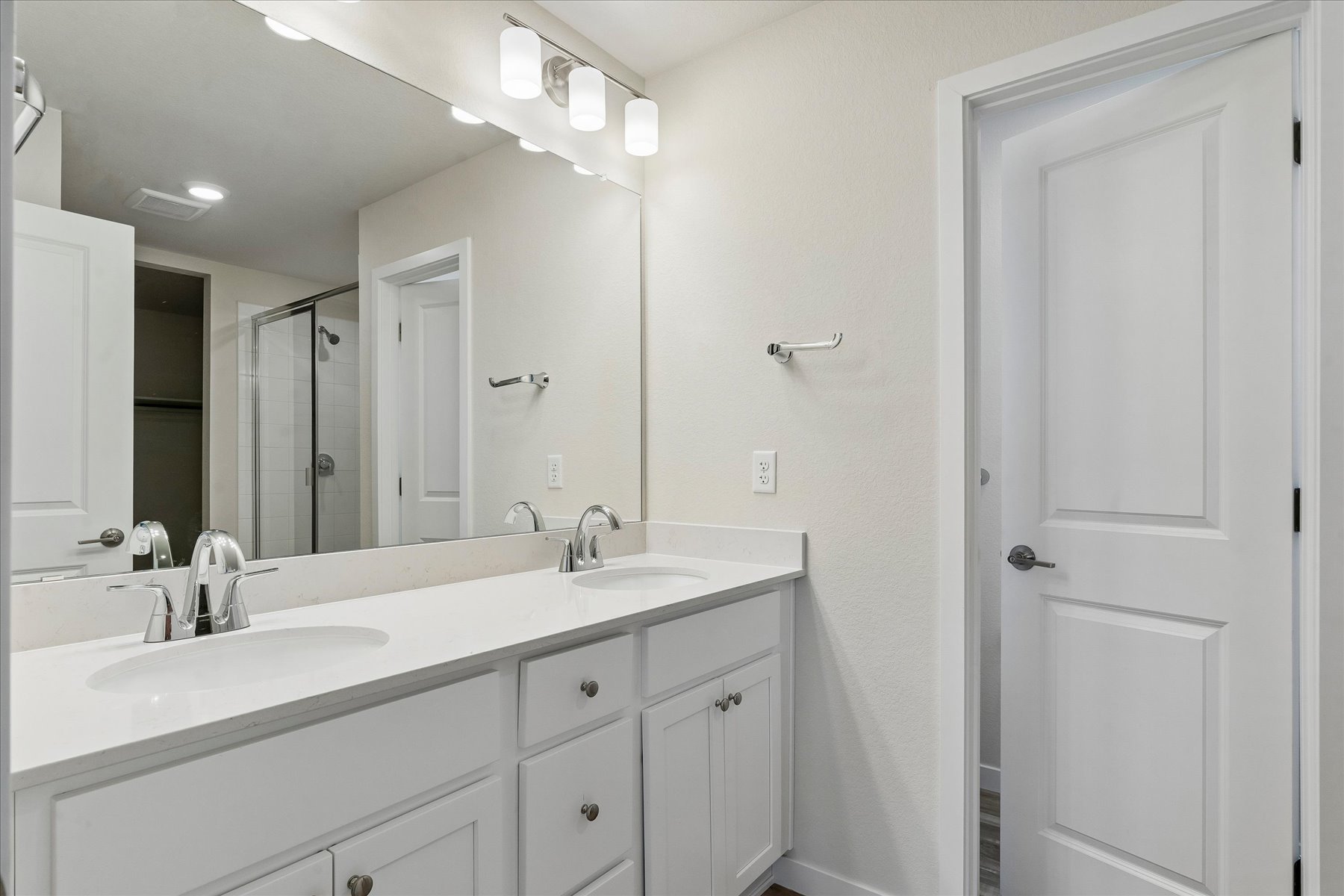 A bathroom with white cabinets.