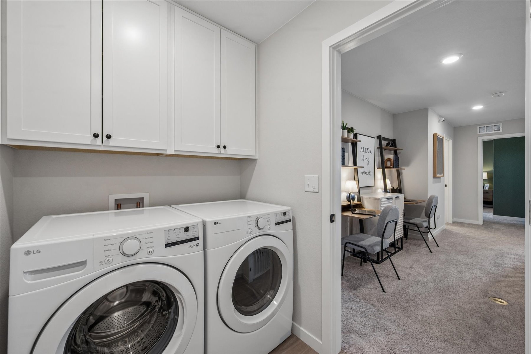 A room with white cabinets and a washing machine.