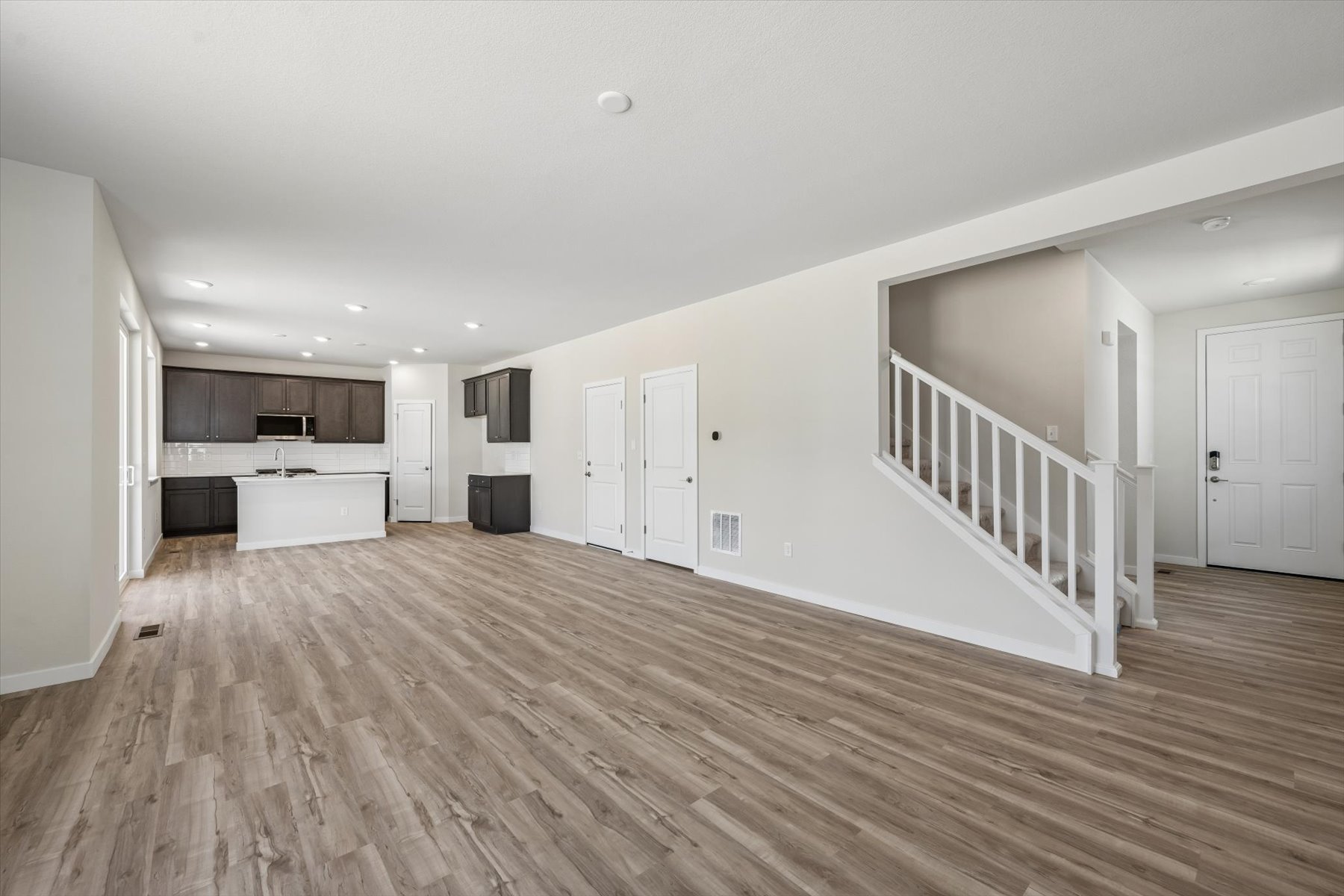 A room with white walls and wood floors.
