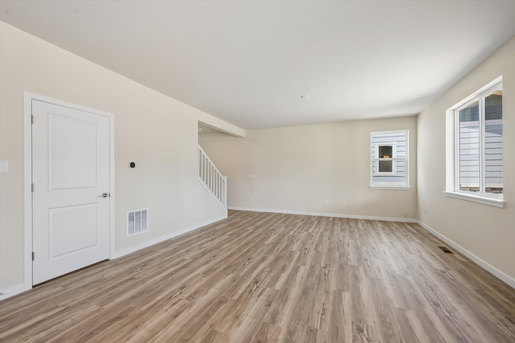 A room with a wood floor and white walls.