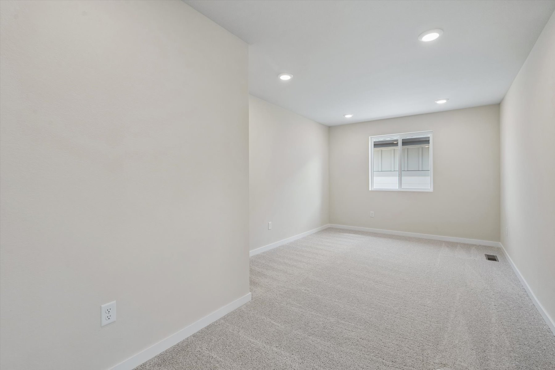 A room with a carpet and a window.