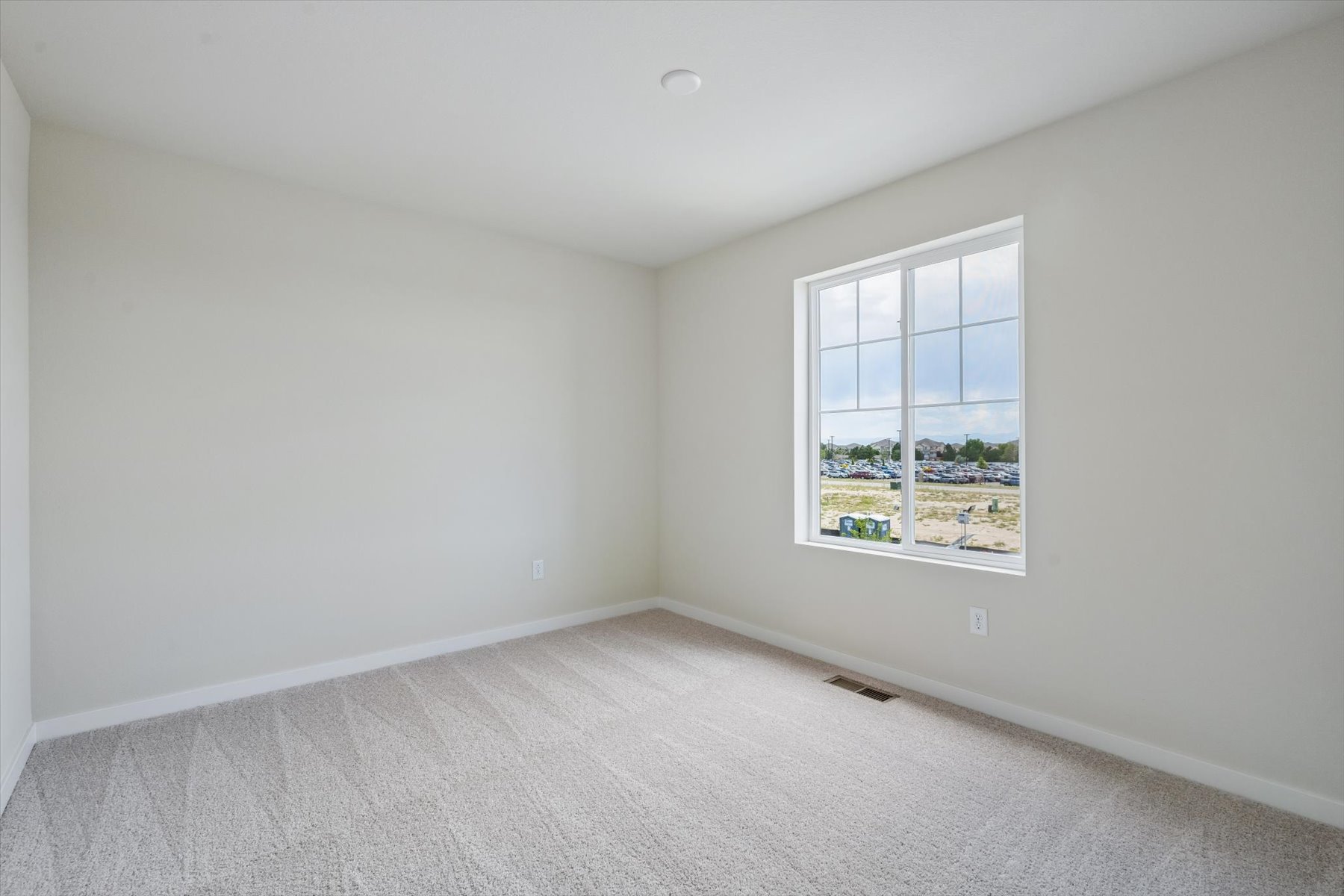 A room with a window and a carpet.