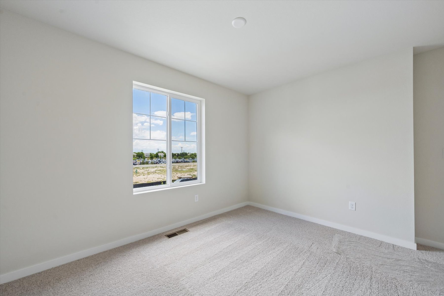 A room with a window and a carpet.