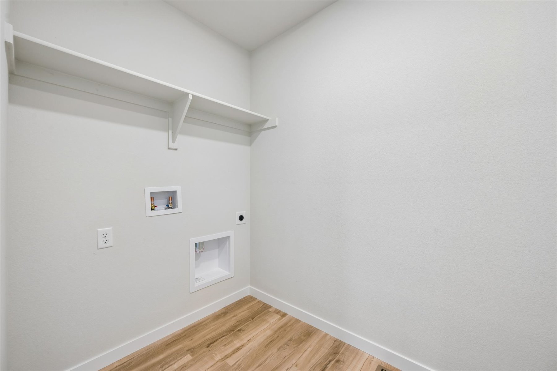 A white room with a wood floor.