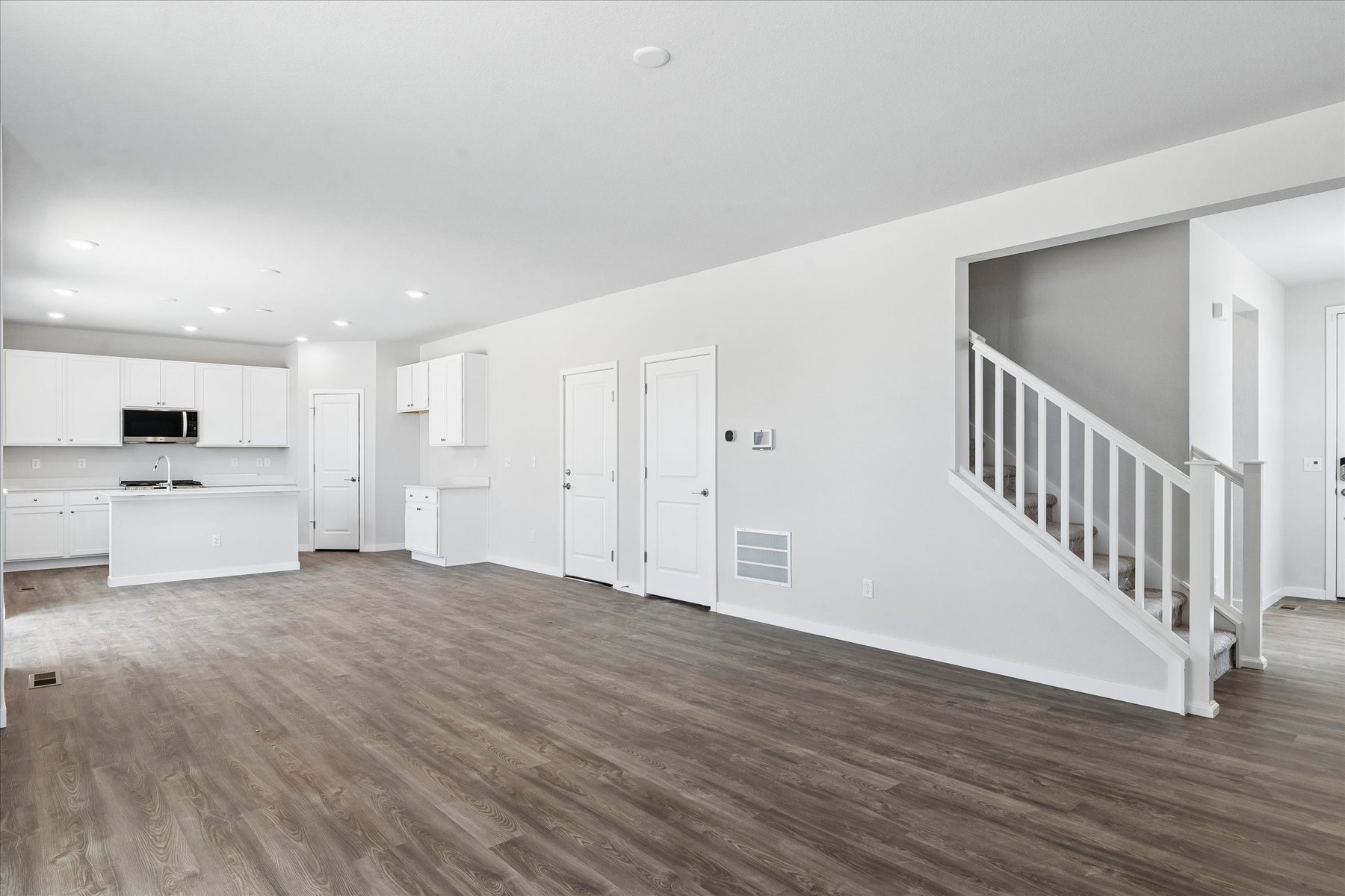 A room with white walls and wood floors.