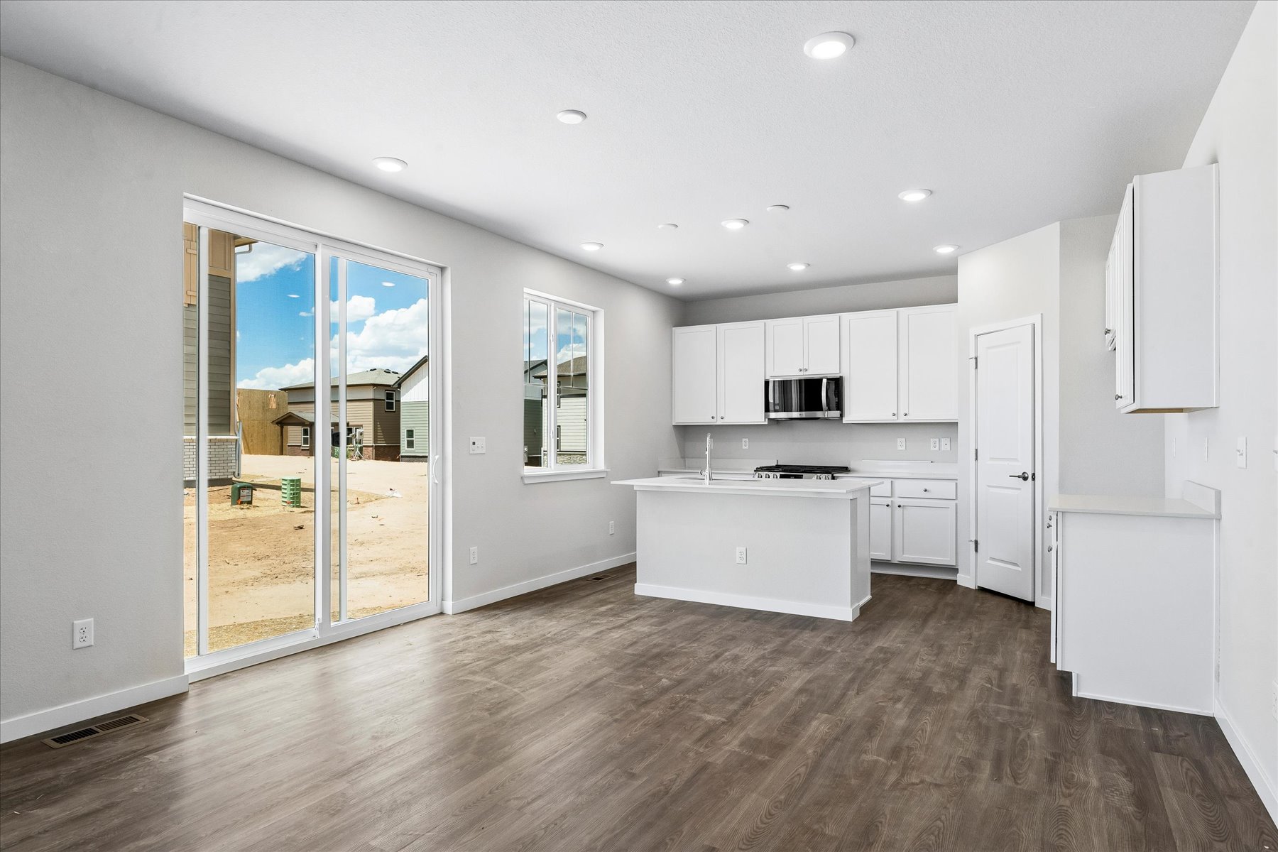 A large white kitchen with a glass door.