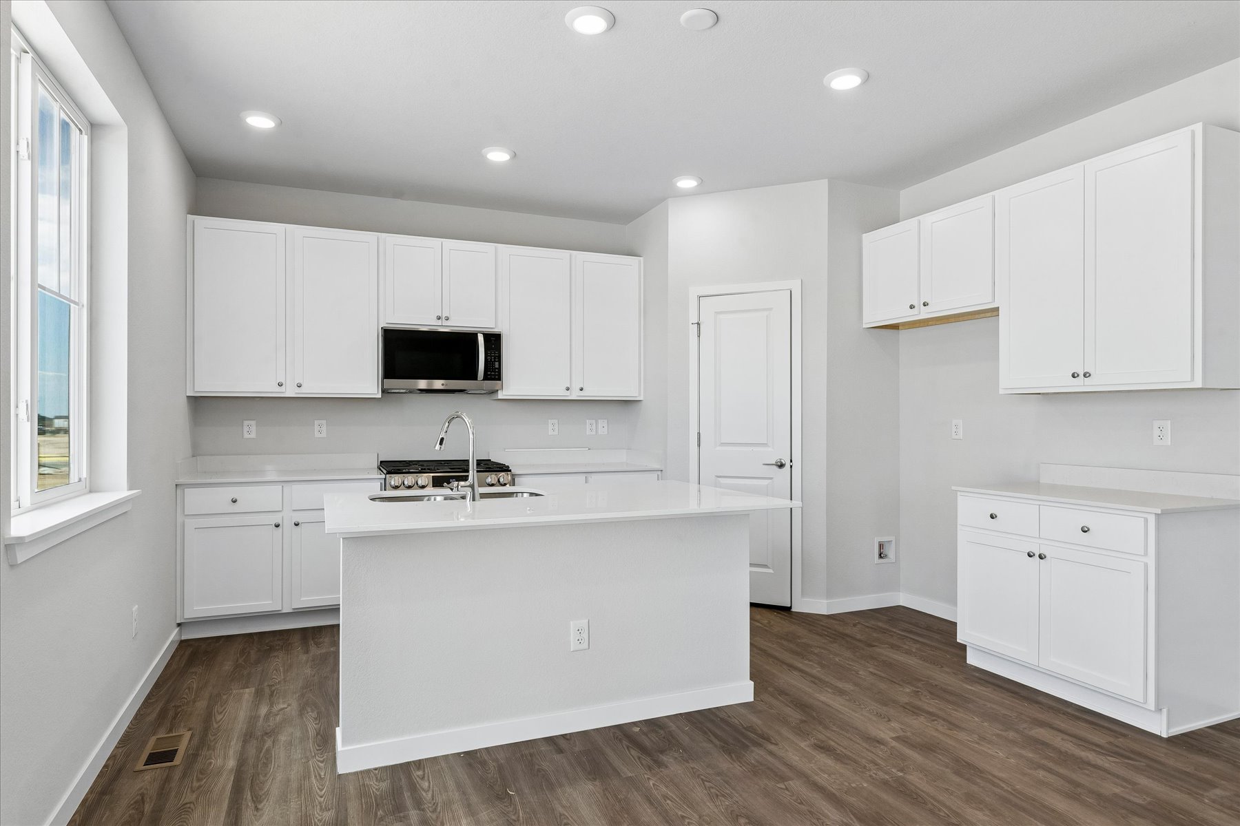A kitchen with white cabinets.
