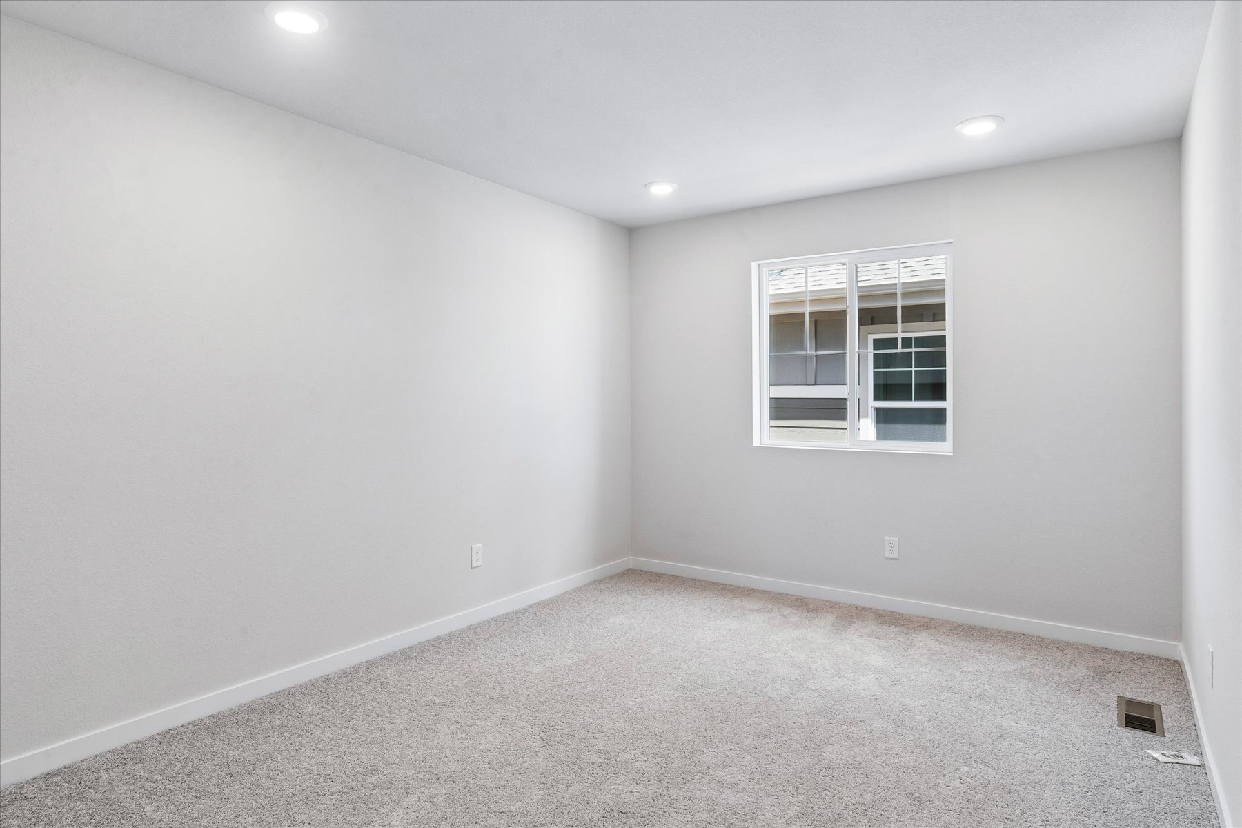 A room with a window and a carpet.