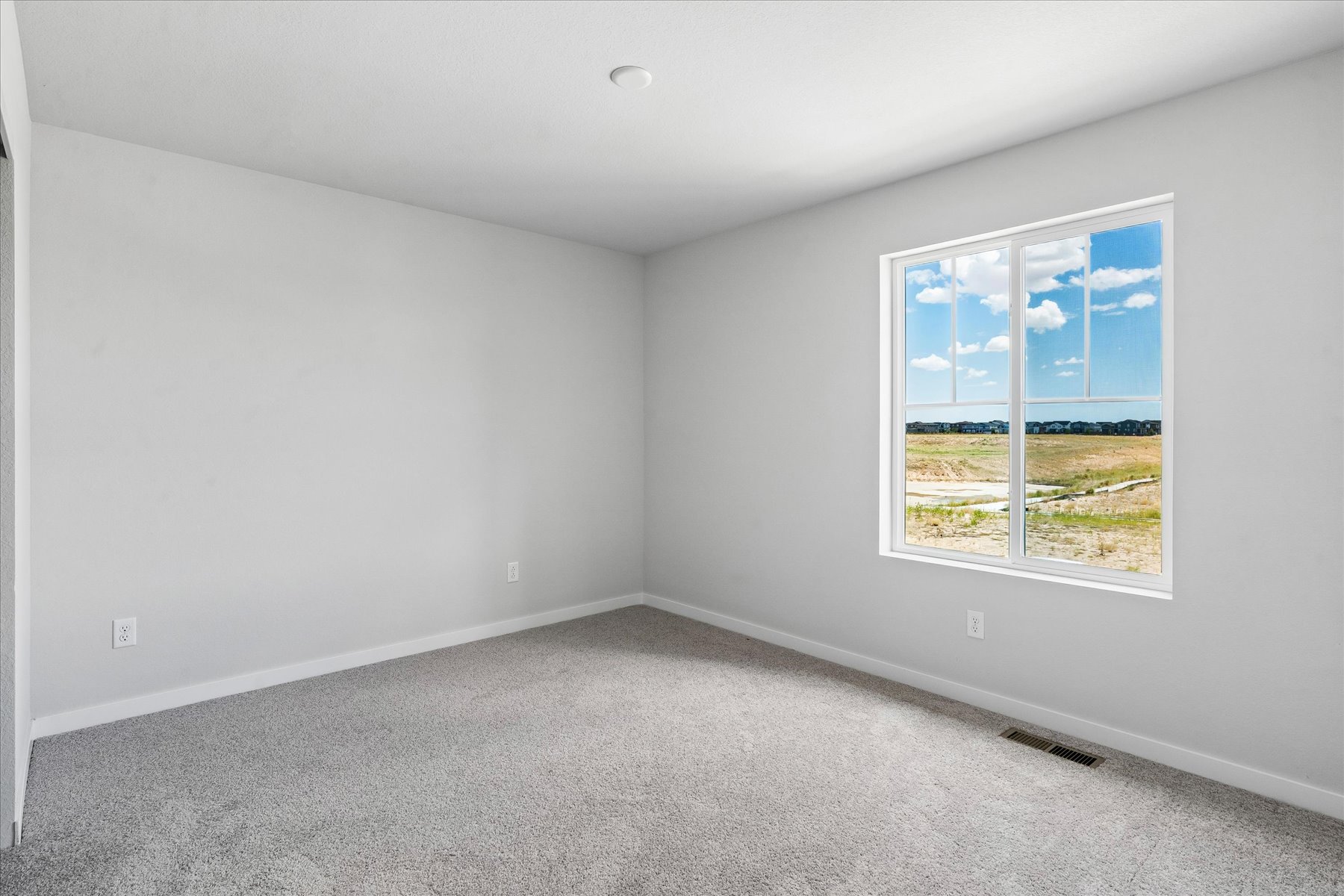 A room with a window and a carpet.