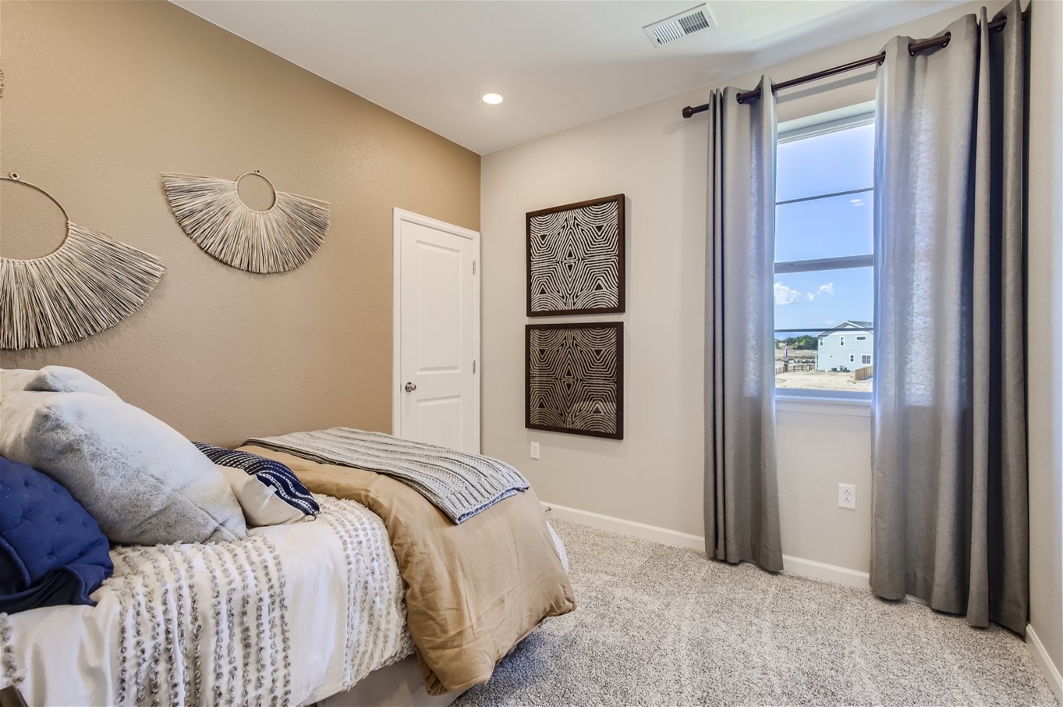 A bedroom with a large window.