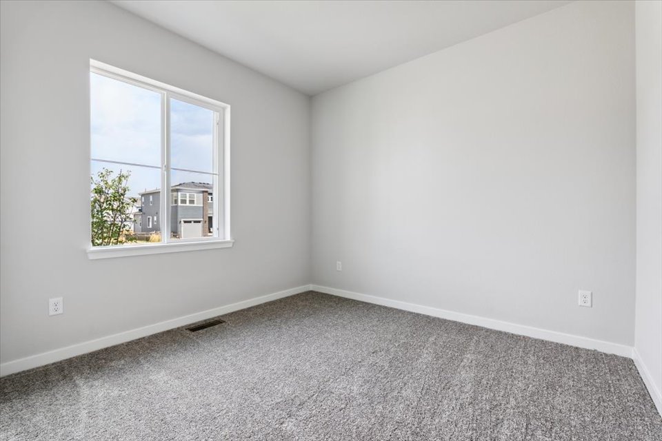 A room with a window and a carpet.