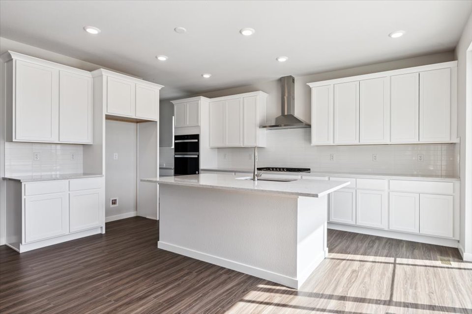 A kitchen with white cabinets.