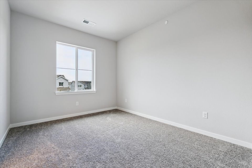 A room with a window and carpet.