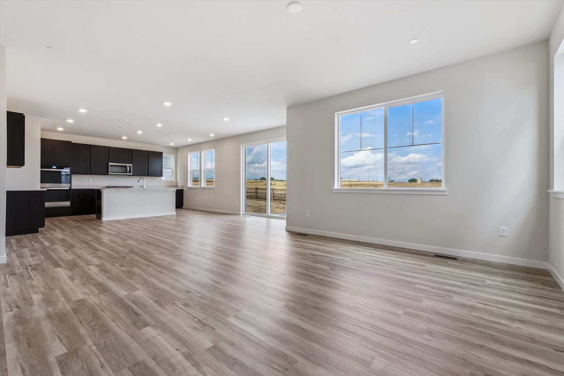 A large empty room with a wood floor and a large window.