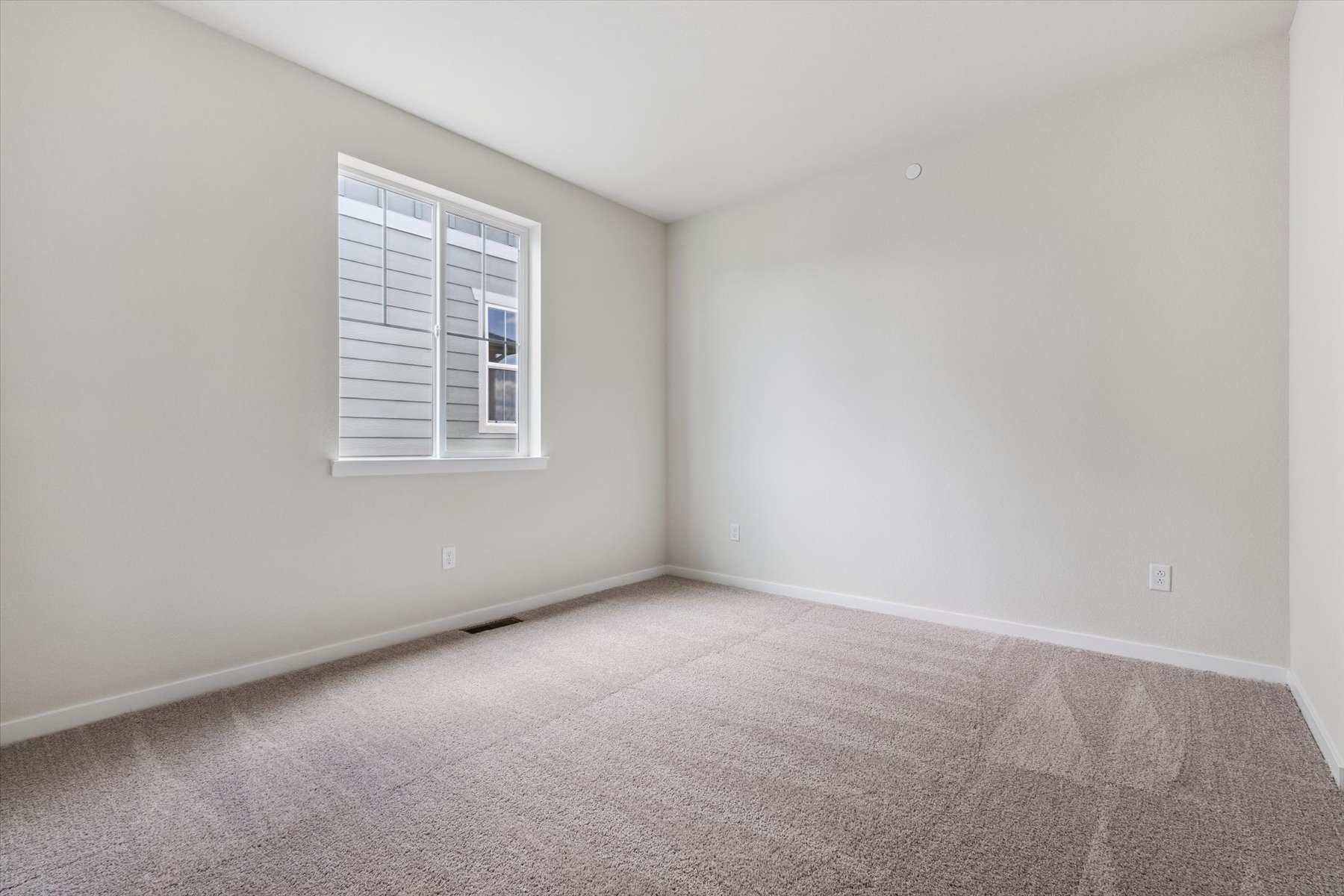 A room with a window and carpet.