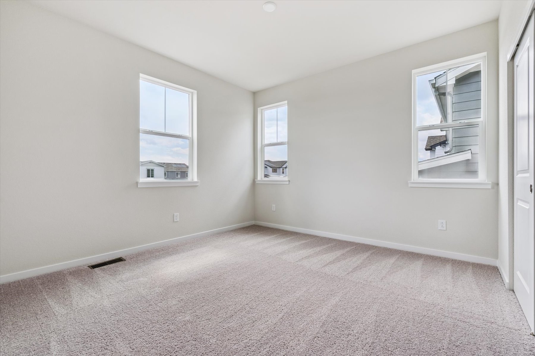 A room with a carpet and windows.