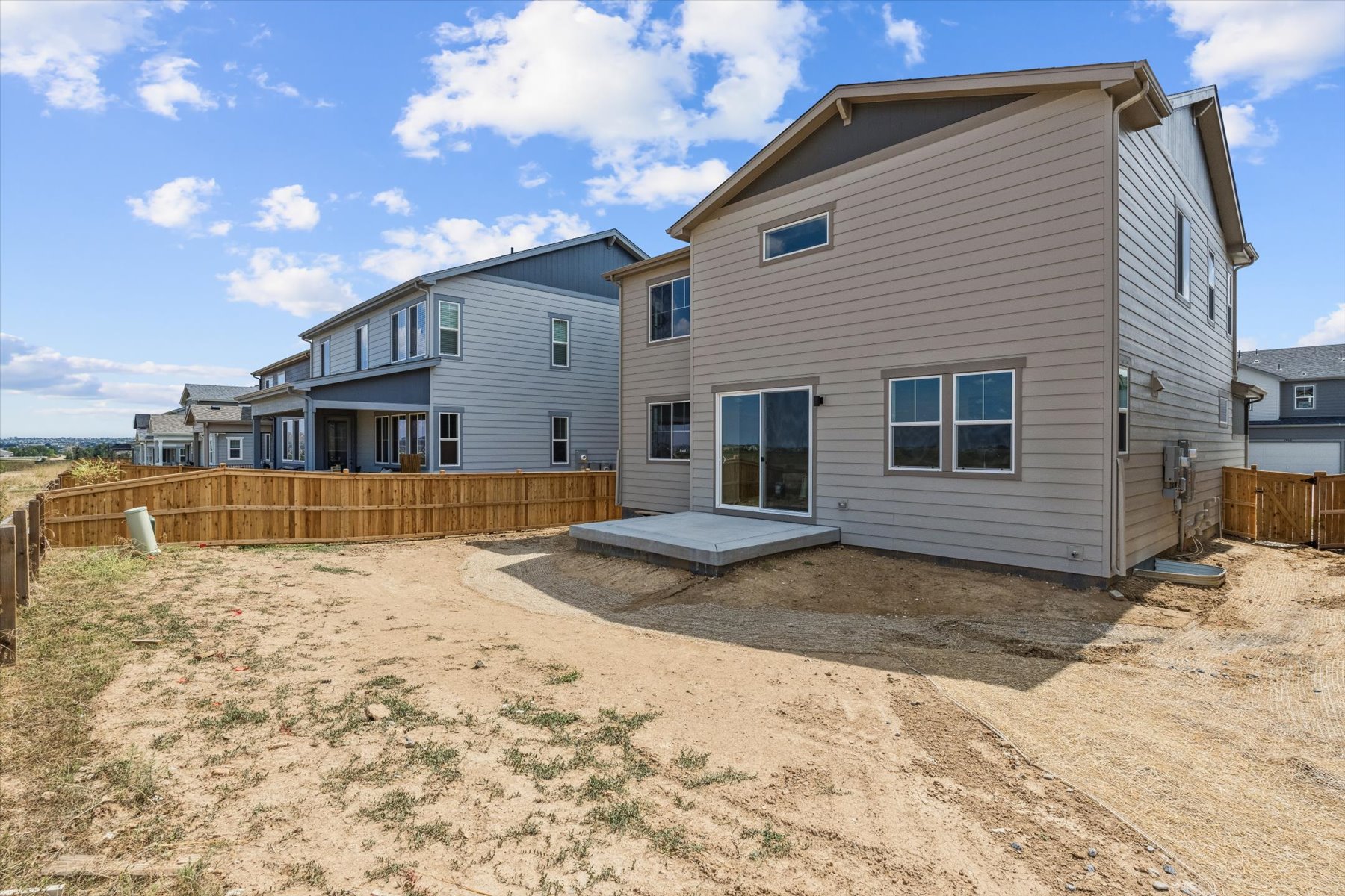A dirt road leading to a house.