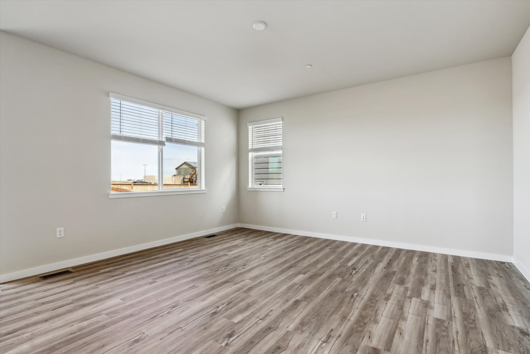 A room with a wood floor and a wood floor with a window.