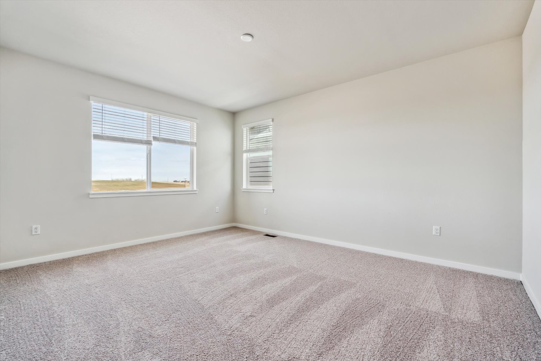 A room with a carpet and a window.