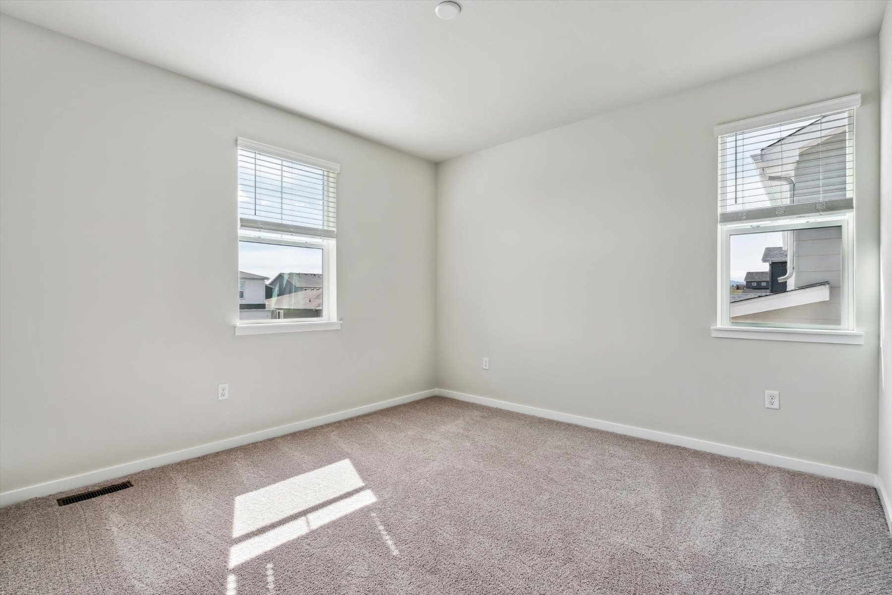 A room with a carpet and windows.