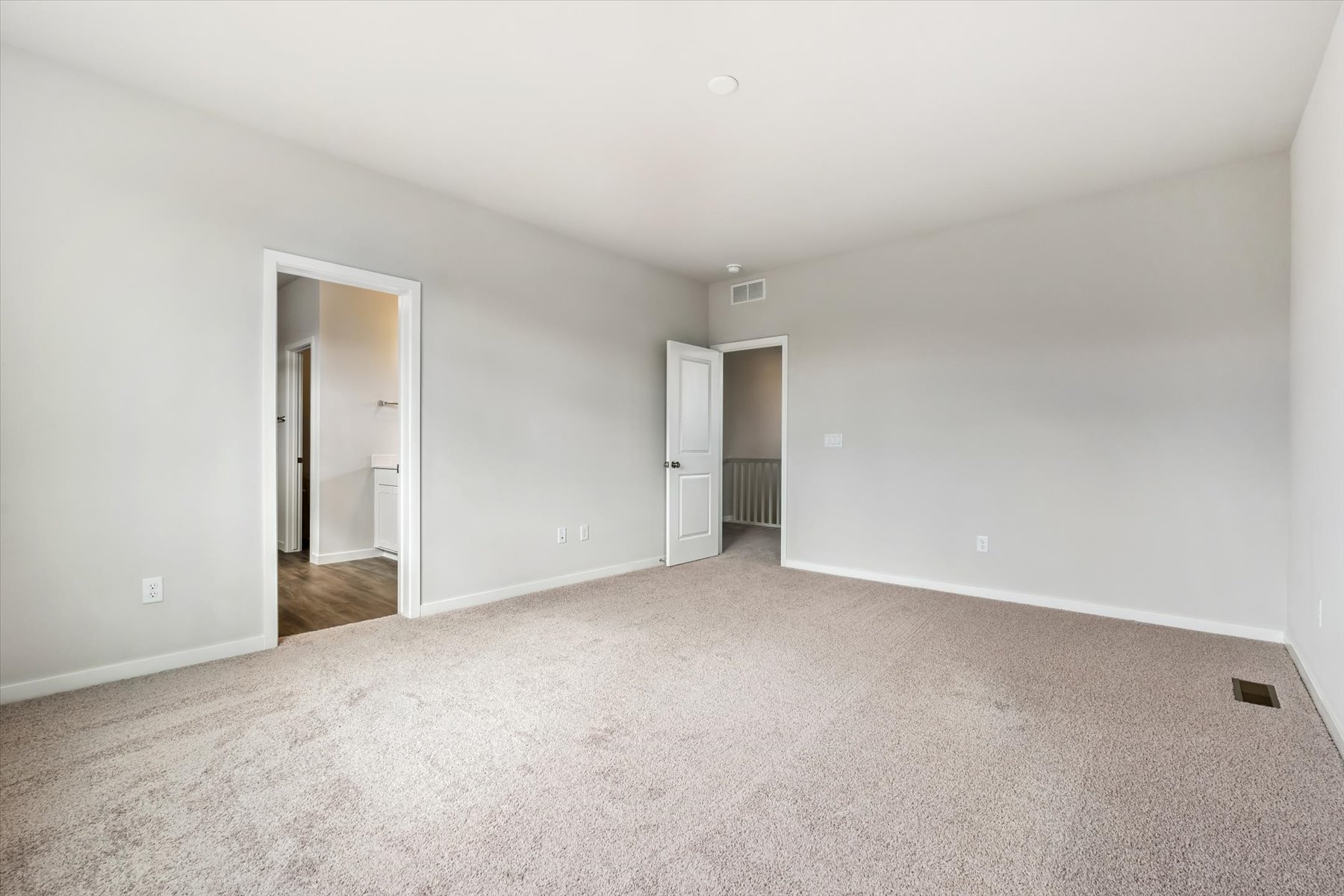 A room with a carpet and a door.