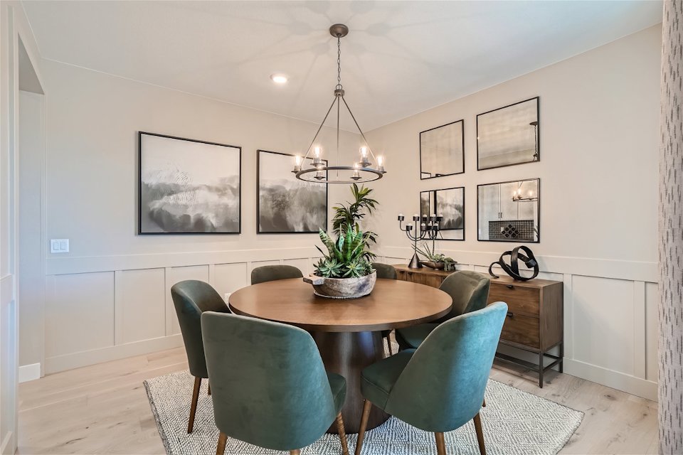 A dining room with a chandelier and chairs.