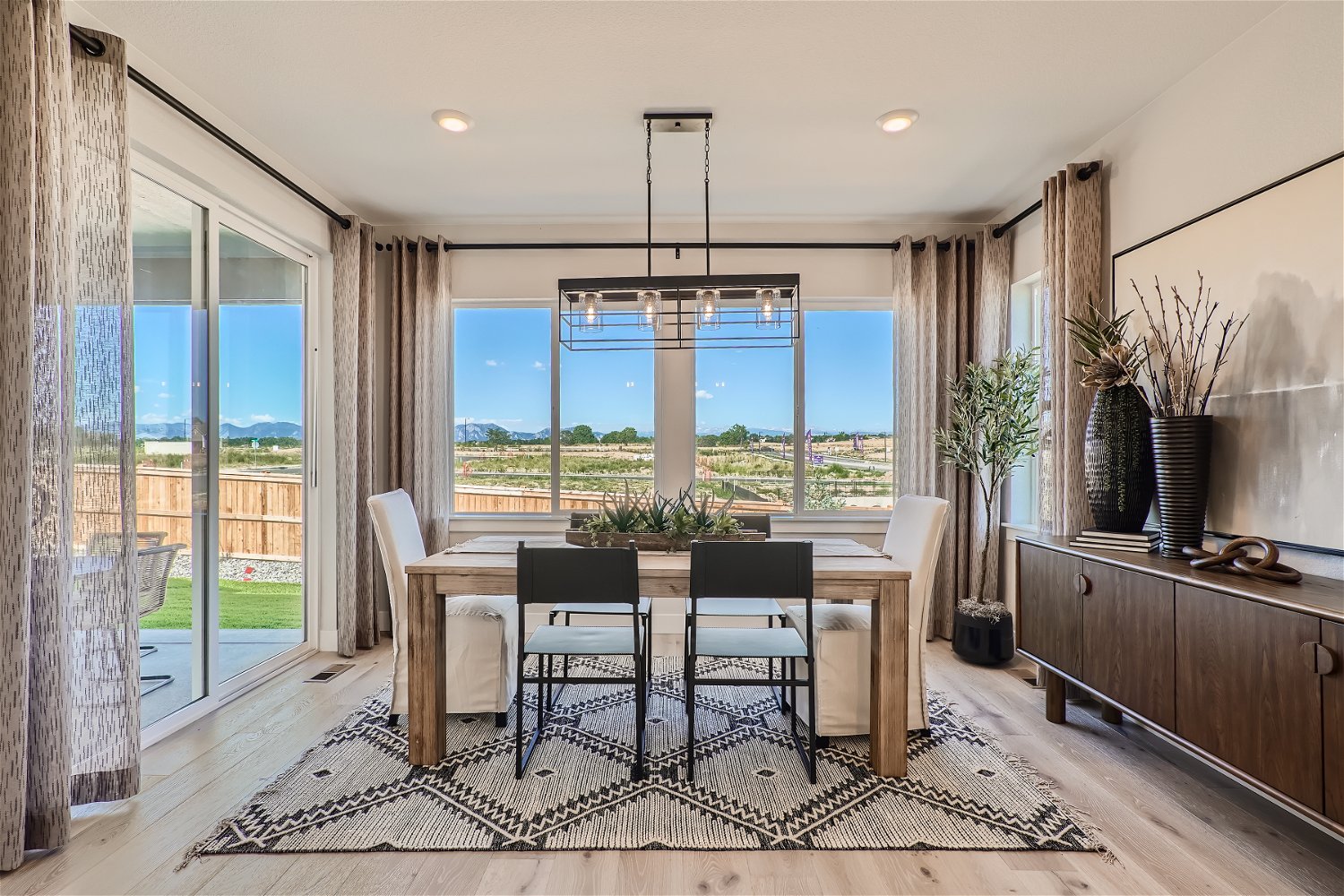 A kitchen and dining room with a large window overlooking a city.