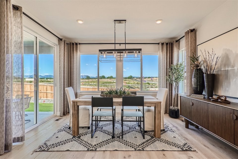 A kitchen and dining room with a large window overlooking a city.