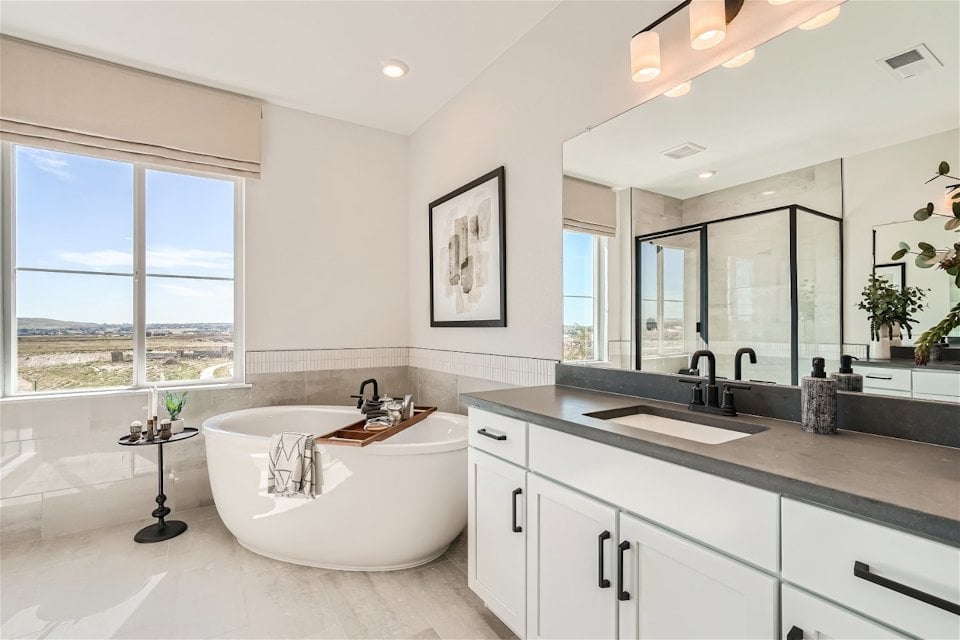 A bathroom with a tub sink and a large window.
