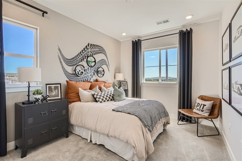 A bedroom with a bed and a chair.