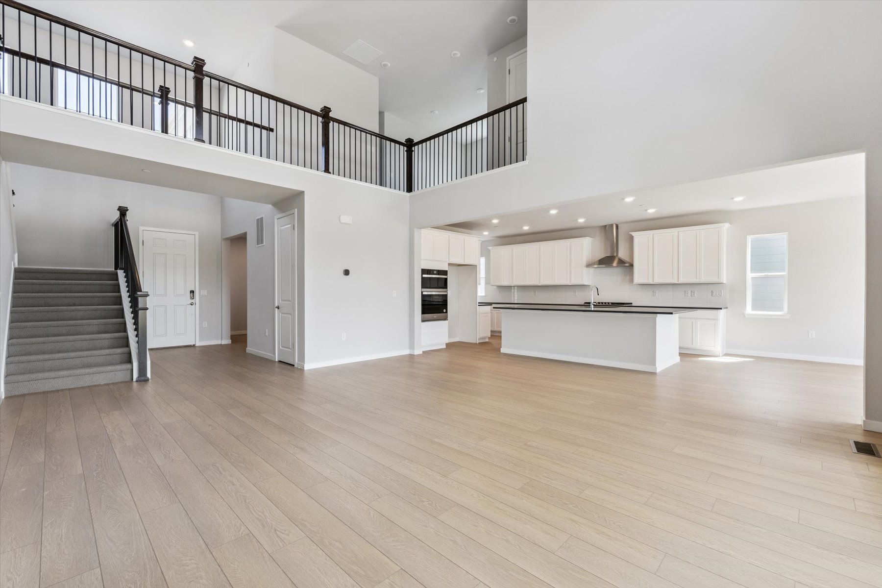 A large empty room with a wood floor and white walls.