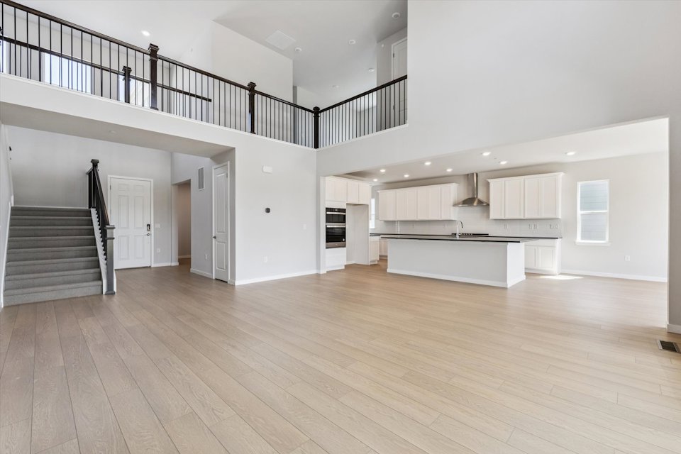 A large empty room with a wood floor and white walls.