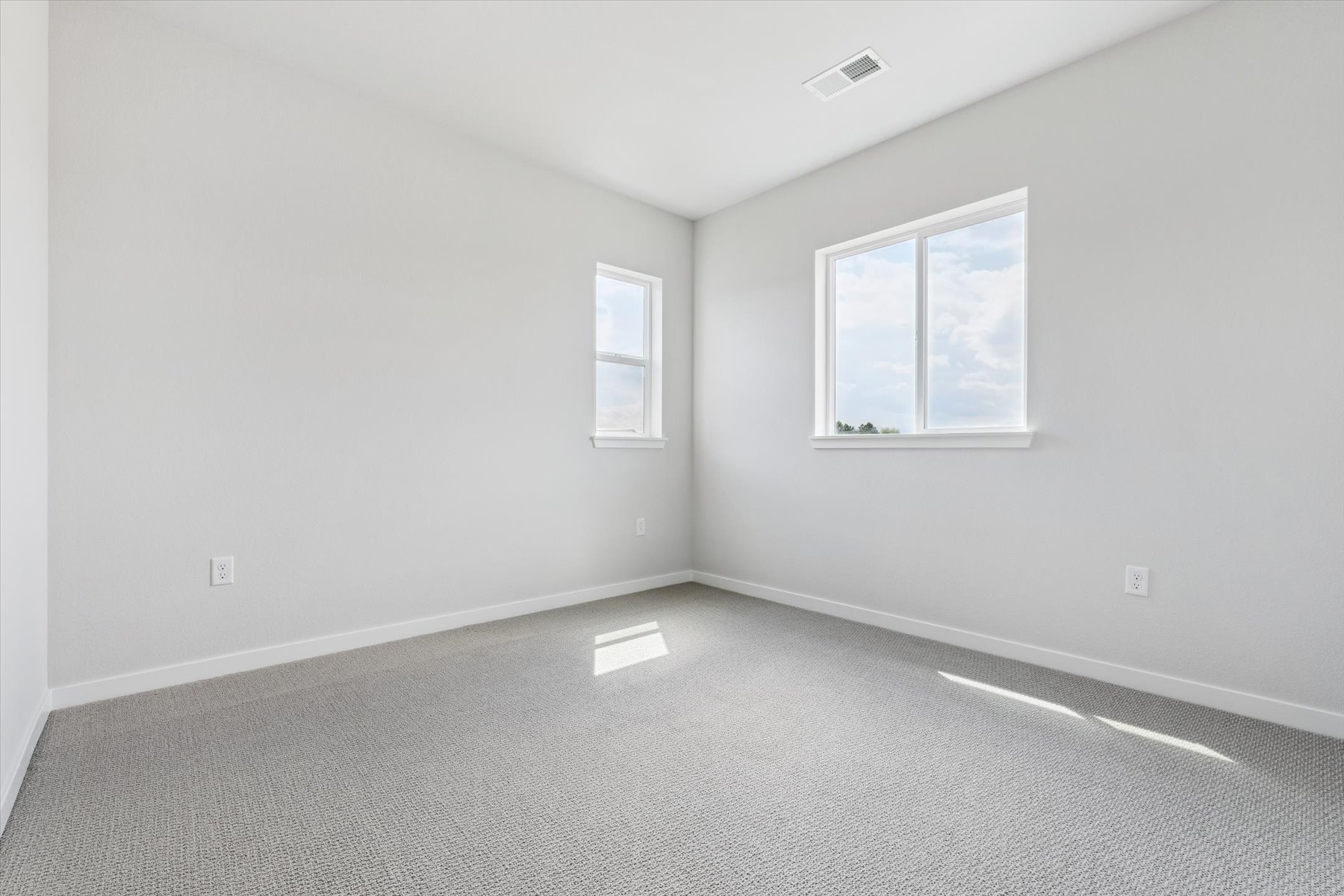 A room with a window and a white wall.