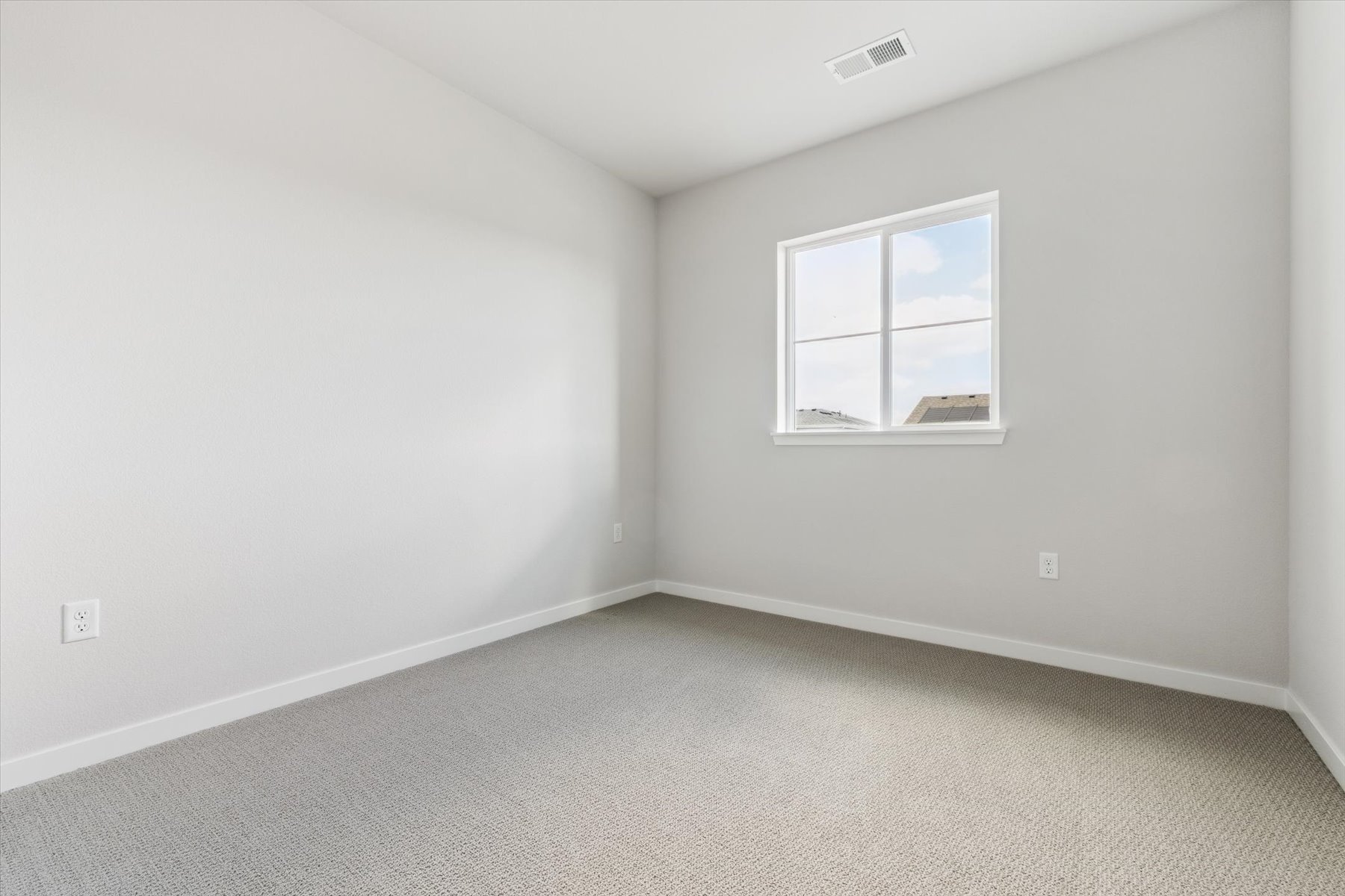 A room with a window and a carpet.