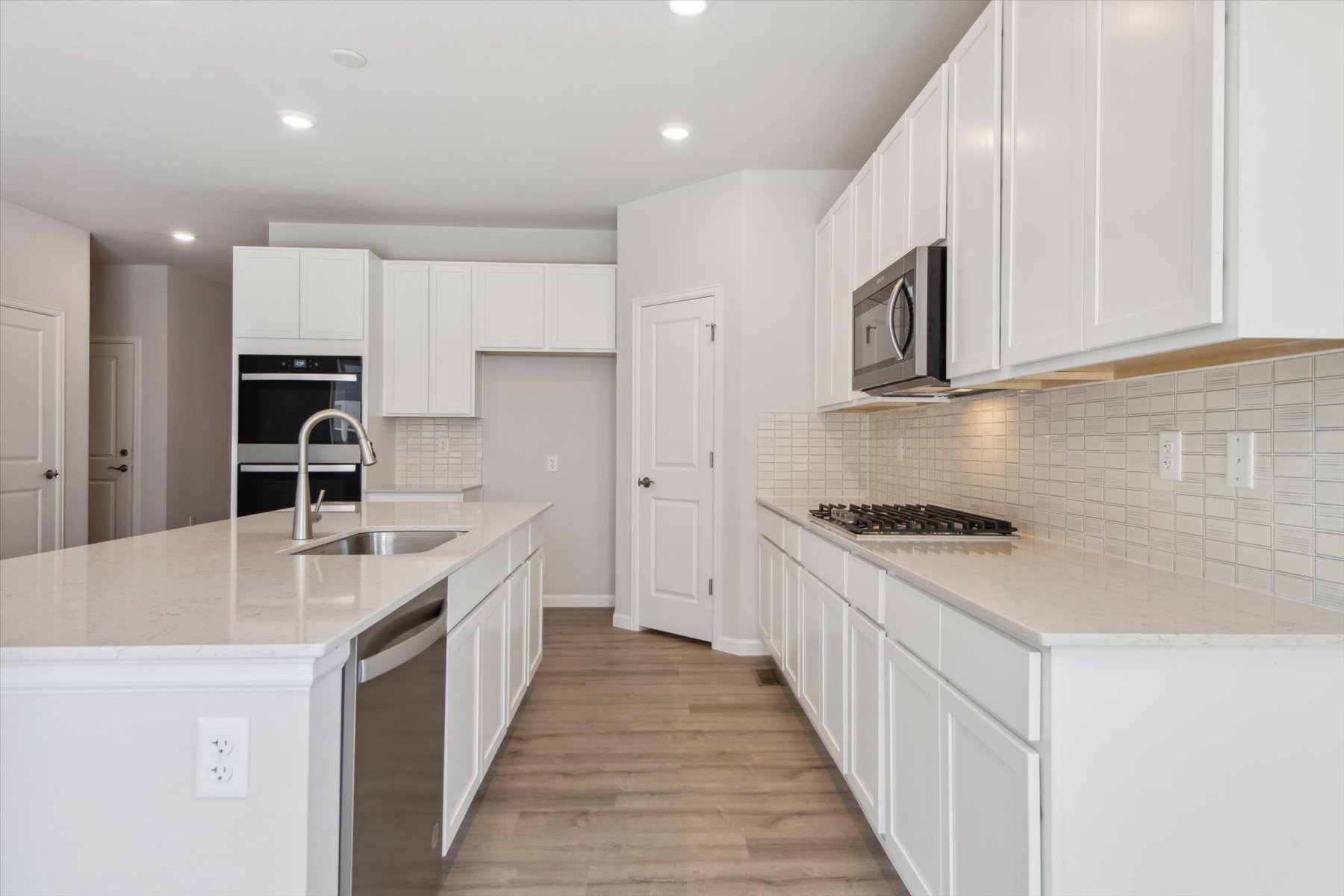 A kitchen with white cabinets.