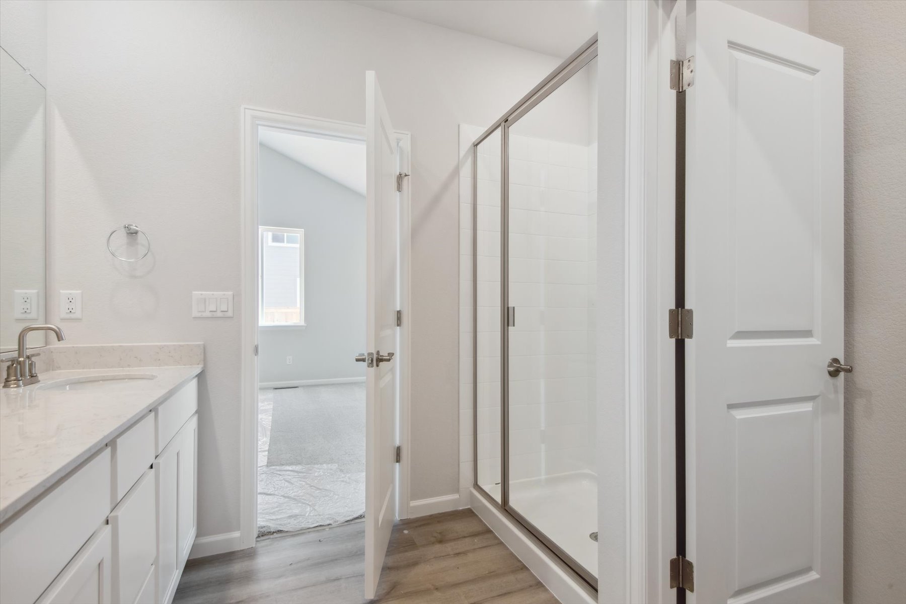 A bathroom with a shower and a glass door.
