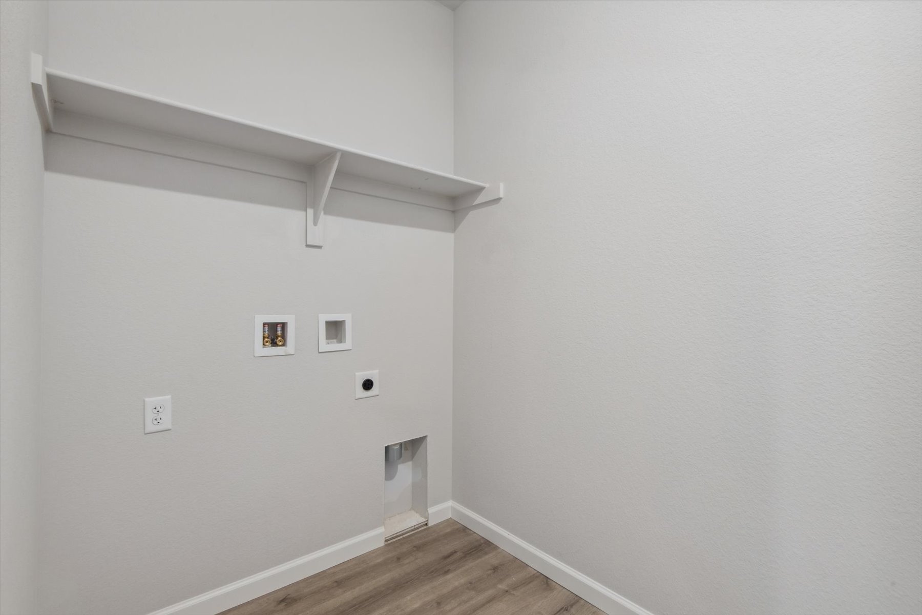 A white wall with a wood floor and a wood floor.