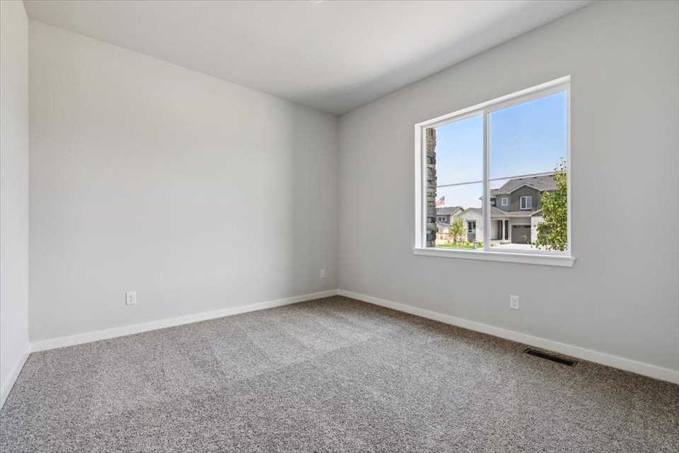 A room with a window and a carpet.