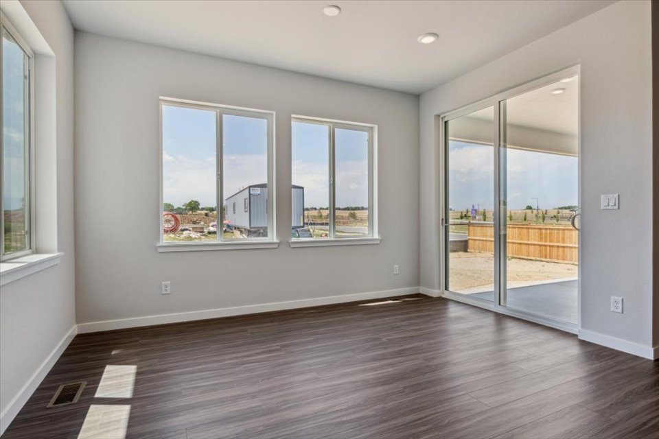 A room with a wood floor and windows.
