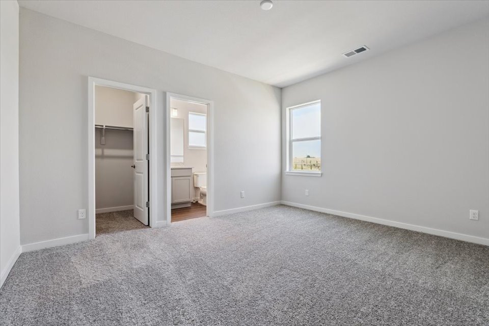 A room with a carpet and a door.