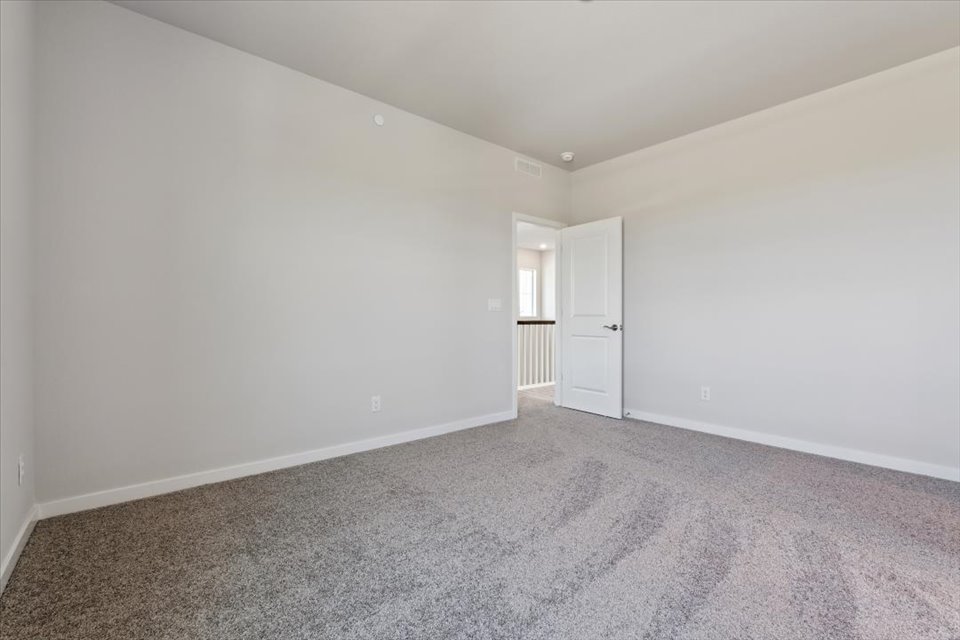 A room with a carpet and a door.