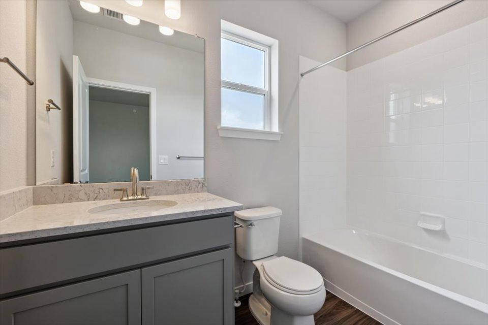 A bathroom with a tub sink and toilet.