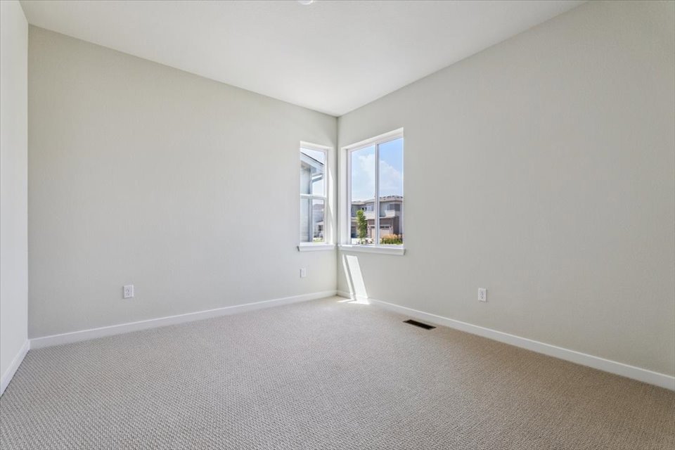 A room with a carpet and windows.
