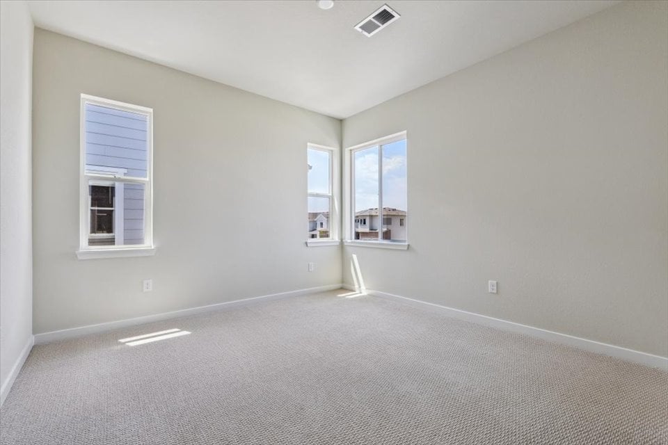 A room with a white carpet and windows.