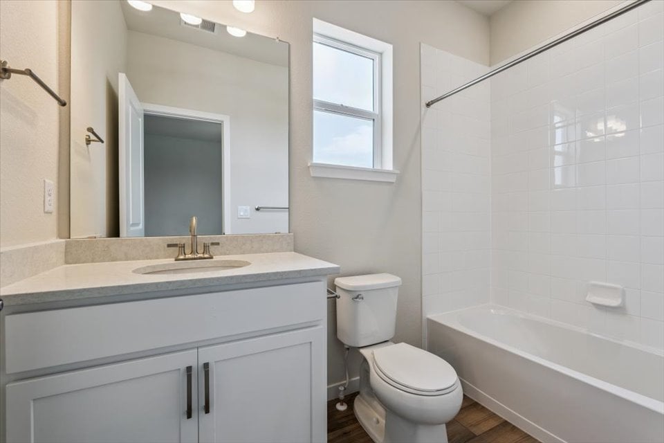 A bathroom with a tub sink and toilet.