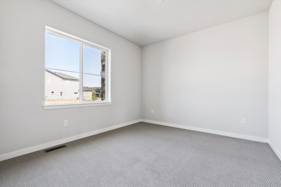 A room with a window and a carpet.